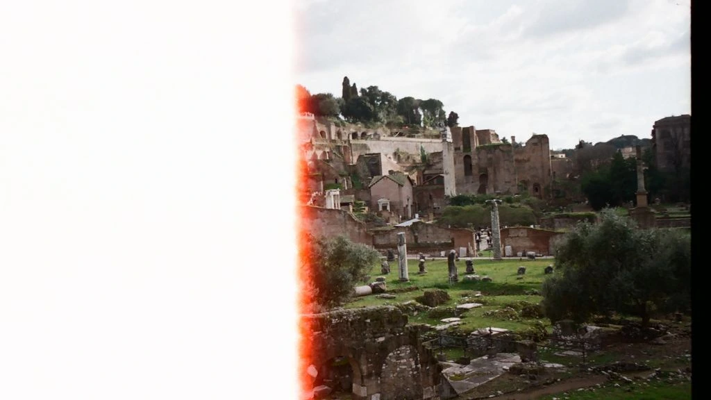 A rooftop view of Roman rooftops at dusk, the kind of vantage seen in 'Roman Holiday' and 'La Grande Bellezza'